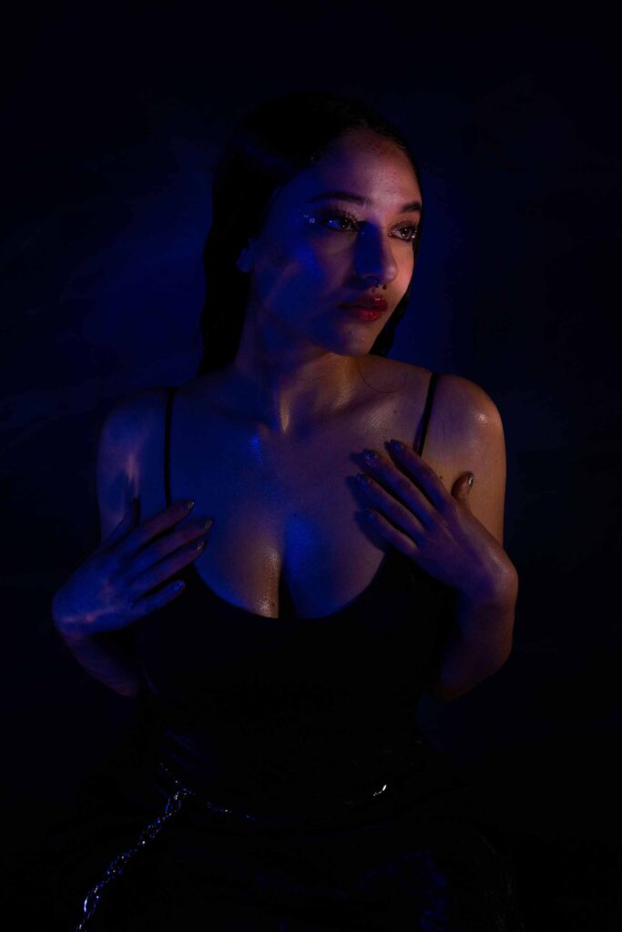 Woman in a dark room lit by blue and pink lights